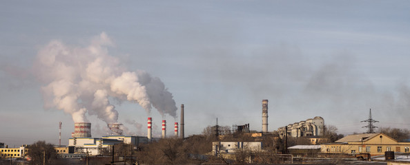 Industrial landscape with metallurgical plant, fuming pipes and white smoke. Metallurgical works with smoke. Industrial architecture.