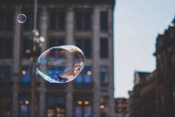 Large Floating Soap Bubble With Buildings On The Background