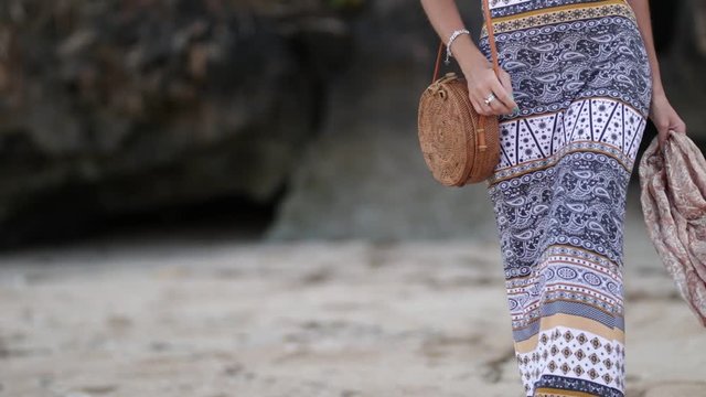 Woman with fashionable stylish rattan bag on the beach. Tropical island of Bali. Handmade Rattan eco handbag HD footage.