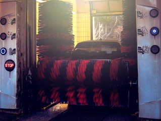Automatic brush car wash in prozess, red and black brushes