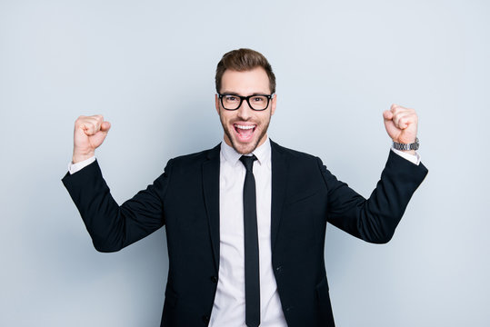 Whoo! We won the tender! Portrait of handsome emotional cheerful excited joyful fun wearing black classic suit man, isolated on gray background