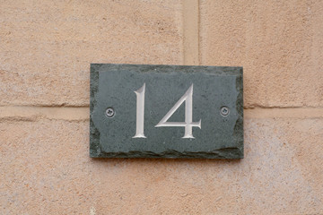 House number 14 sign on slate fixed to wall