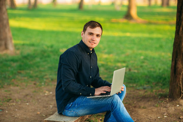 The young manager working on a laptop in the park. Lunch Break