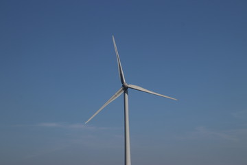Fototapeta premium Windturbine in close-up with blue sky as background in the Netherlands.