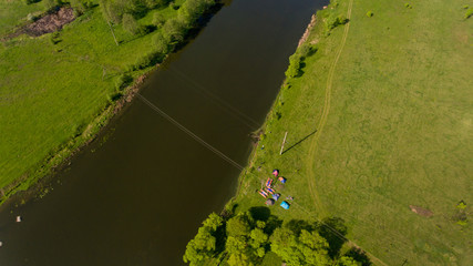 Aerial view of camp of tourists with tents on the river bank.