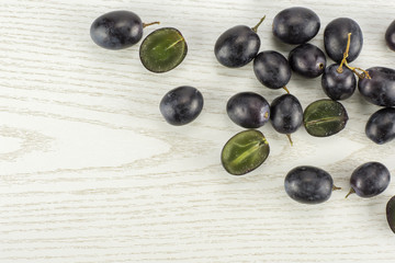 Black grape berries (autumn royal variety) some sliced table top isolated on grey wood background.