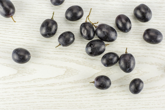 Black grape berries (autumn royal variety) table top isolated on grey wood background.