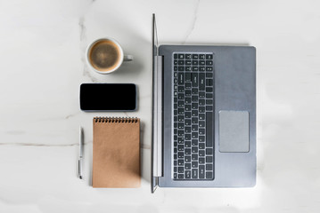 Workplace, white desk table with laptop, smartphone, coffee cup and notepad, Copy space