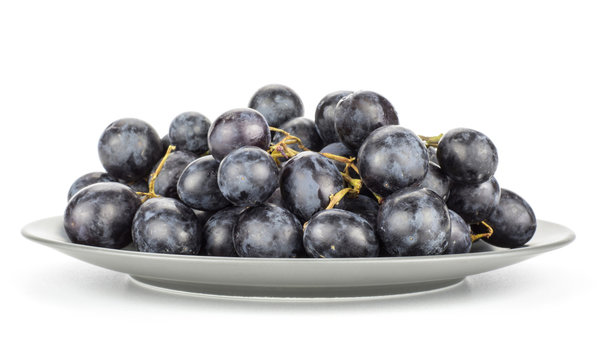 Black purple grape cluster (autumn royal variety) on a grey plate isolated on white background.