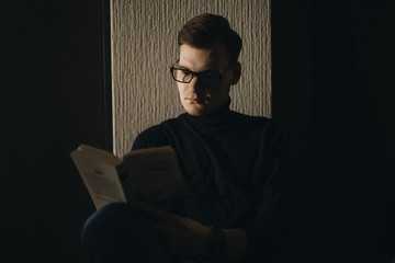 Serious young manager with glasses reading his daily book