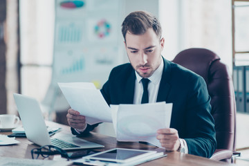 Marketing count report speech account people career executive concept. Tired busy concentrated focused smart clever intelligent handsome entrepreneur looking at document in his hands reading crefully