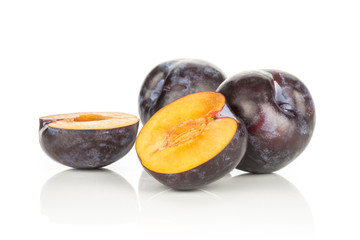Two red blue plums and two halves isolated on white background.