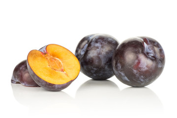 Two red blue plums and two sliced halves isolated on white background.