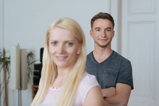 Man and blonde woman standing in domestic room