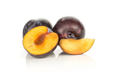 Two red blue plums one half and a slice isolated on white background.