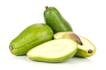 Green smooth avocado set two whole and one cut in two halves with a brown seed isolated on white background bacon variety.