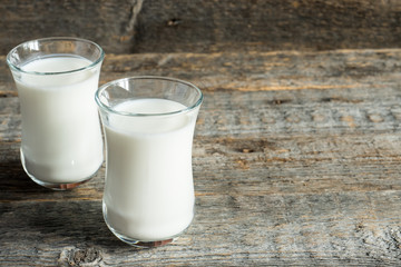 Fresh healthy milk in glass cups on wooden rustic background