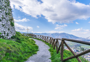 Fototapeta na wymiar Beautiful landscape, mountain path with a wooden fence and steel cross. The Italian Apennines.
