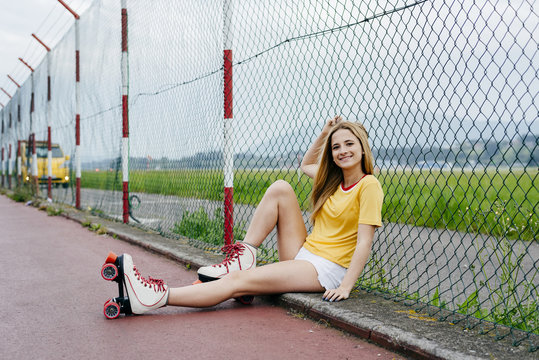 Trendy girl in roller blades on street