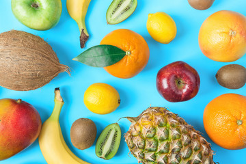 Pattern from Different Tropical and Seasonal Summer Fruits. Pineapple Mango Coconut Citrus Oranges Lemons Apples Kiwi Bananas Scattered on Light Blue Background.Healthy Lifestyle Vitamins. Flat Lay