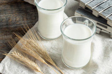 Fresh healthy milk in glass cups on wooden rustic background