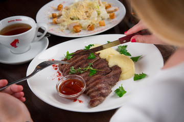 Едим стейк. We're eating steak.