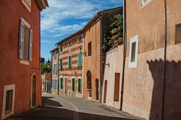 View of traditional colorful houses in ocher and street in the city center of the village of Roussillon. Located in the Vaucluse department, Provence region, southeastern France