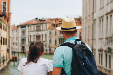 Plakat Back view of a Couple standing on the bridge over the canal at the Venice - Italy