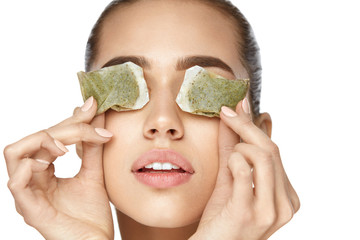 Eye Skin Care. Beautiful Woman With Green Tea Bag Under Eyes