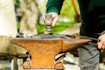 blacksmith with an anvil and a hammer on the street