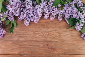 The beautiful violet lilac on a old wooden background. Flat lay and copy space composition.