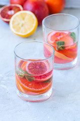 Refreshing blood orange water or infused water in a glass on a wooden background.