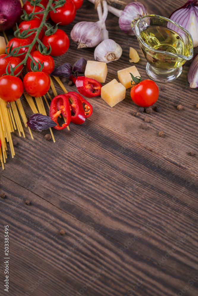 Wall mural Ingredients for cooking spaghetti - raw pasta, tomato, olive oil, spices, herbs