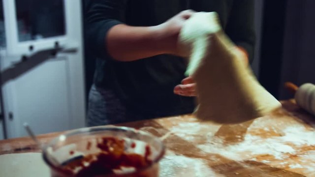 Hands kneading pizza dough in the kitchen