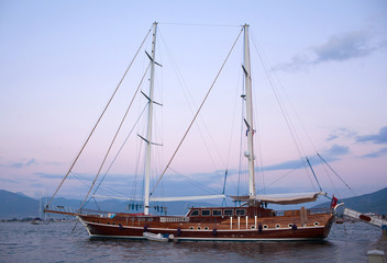 Obraz na płótnie Canvas Beautiful luxury yacht in the calm sea at sunset