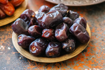 Close up of dried dates or kurma in a vintage plate.