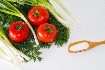 Green onions, tomatoes, dill and sal lying on a white background