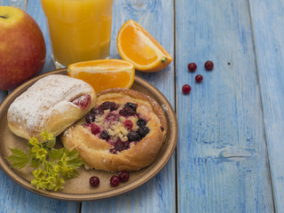 buns with berries on a blue wooden table. 