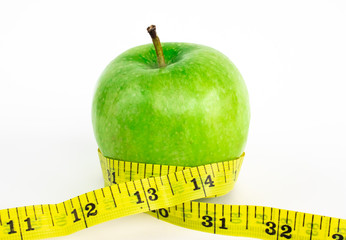 Green apple with yellow measuring tape
