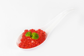 Plastic spoons with fish caviar on a white background. 
