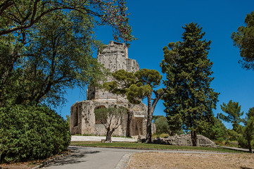 View of the Tour Magne (Magna tower) with blue sky, in the high part of the Gardens of the Fountain, in the city center of Nimes. Located in the Gard department, Occitanie region in southern France