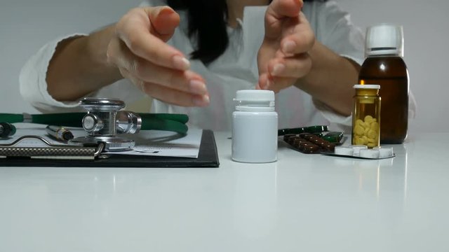female doctor demonstrates a jar of pills