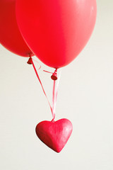 Red decorative heart in red balloons on a light background. Romantic image