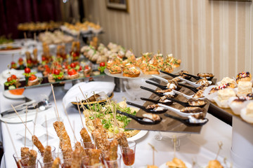 Buffet table of reception with burgers, cold snacks, meat and salads