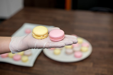 Female hands put together French macaron