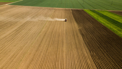 Farmer with a tractor on the agricultural field sowing. tractor working on the agricultural field...