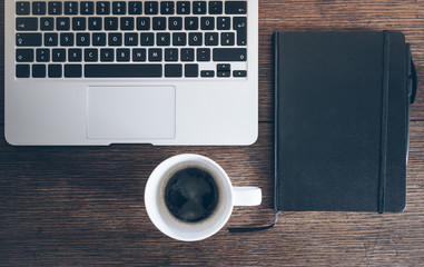 laptop computer, diary and cup of coffee on old rustic wooden table
