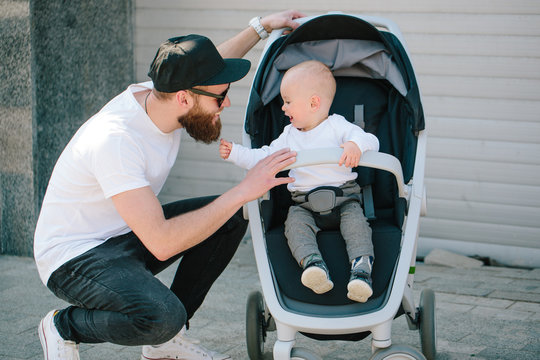 Father walking with a stroller and a baby in the city streets