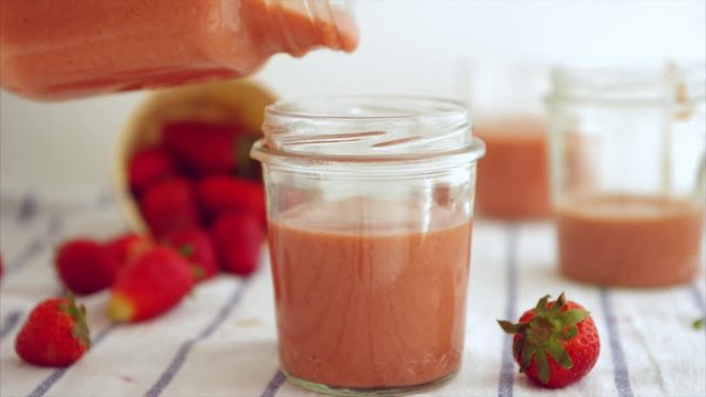 Pouring Strawberry smoothies in a glass, made with strawberries and almond milk,, detox concept , healthy lifestyle.