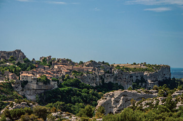 Panoramic view of the village and ruins of the Baux-de-Provence Castle on top of cliff and sunny blue sky. Bouches-du-Rhone department, Provence-Alpes-Côte d'Azur region, southeastern France